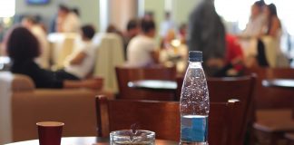 Kawiarniany stolik na lotnisku z butelką wody i kubkiem kawy