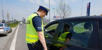Kontrola drogowa - policjant zatrzymuje kierowcę samochodu